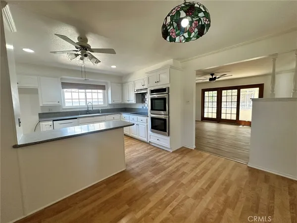 a large kitchen with stainless steel appliances a large counter top a sink a stove a refrigerator and a window