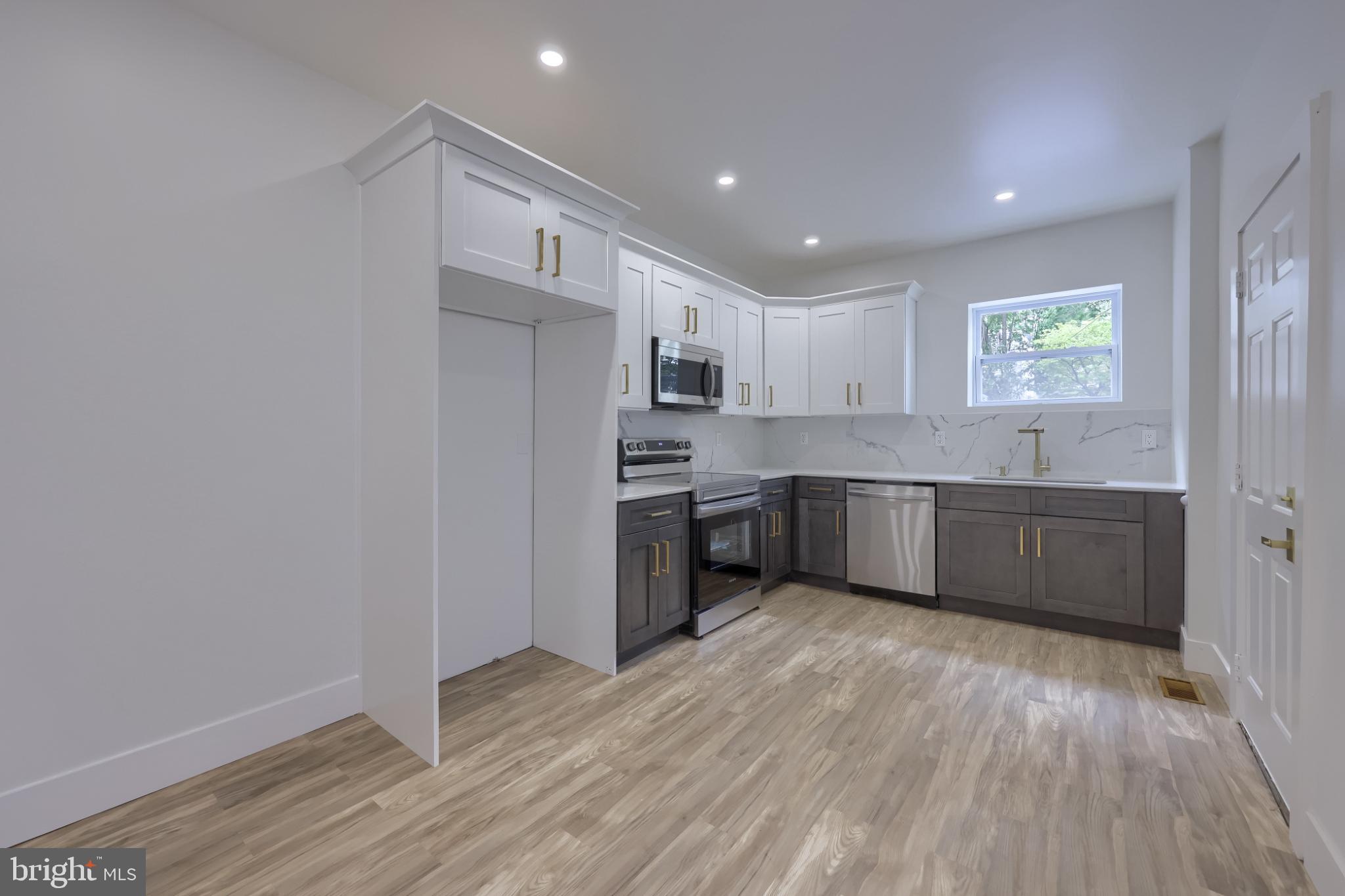 610 East Madison Street Lancaster, PA 17602 - Photo 39 of 68 a kitchen with stainless steel appliances granite countertop a sink cabinets and wooden floor