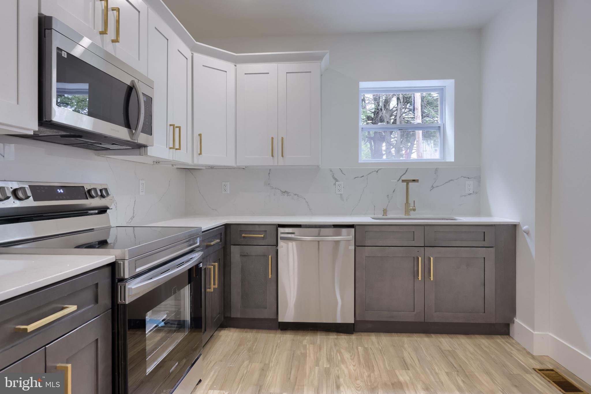 610 East Madison Street Lancaster, PA 17602 - Photo 40 of 68 a kitchen with stainless steel appliances granite countertop a sink a stove a microwave and wooden floors