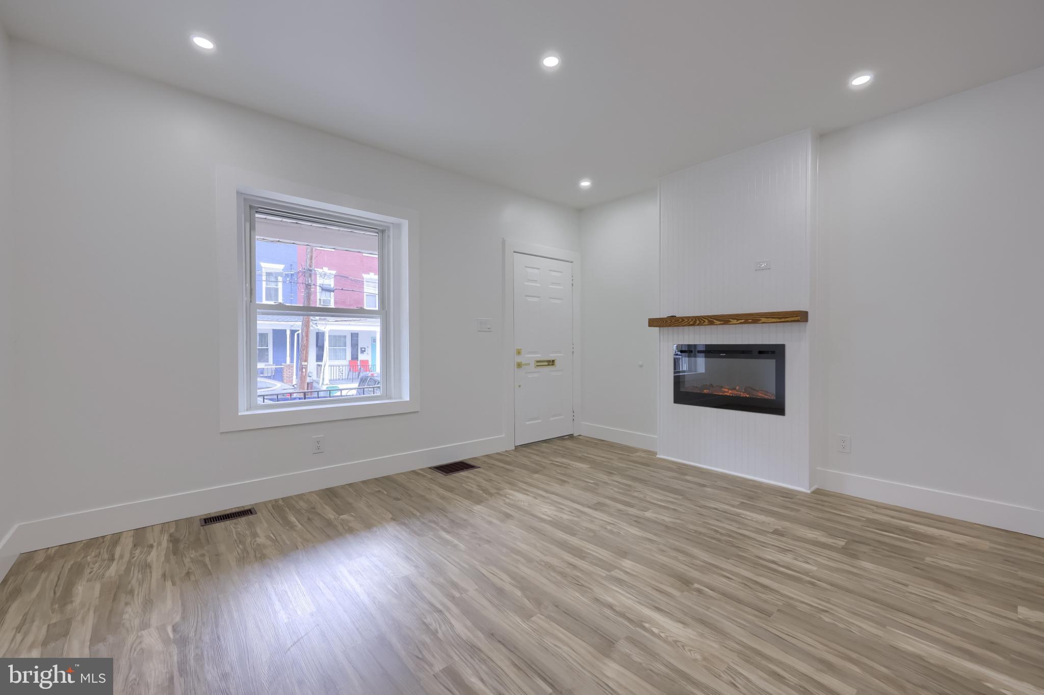 610 East Madison Street Lancaster, PA 17602 - Photo 45 of 68 an empty room with wooden floor and a fireplace