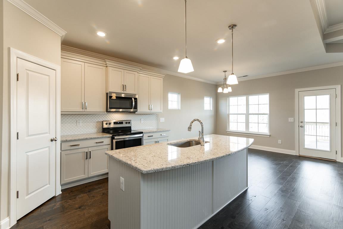 411 Butler Road Mount Juliet, TN 37122 - Photo 4 of 30 a kitchen with a sink a center island a stove cabinets and a wooden floor
