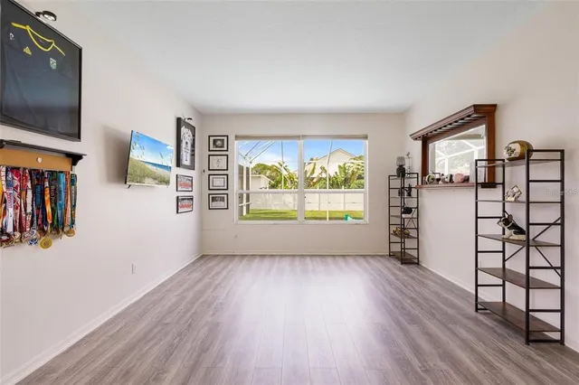 a view of empty room with wooden floor and window