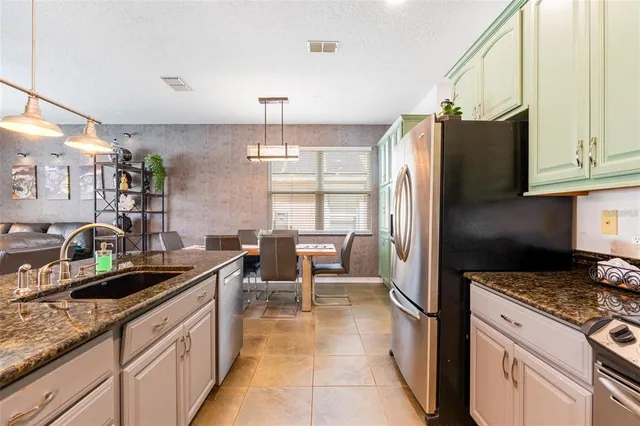 a kitchen with granite countertop sink cabinets and stainless steel appliances
