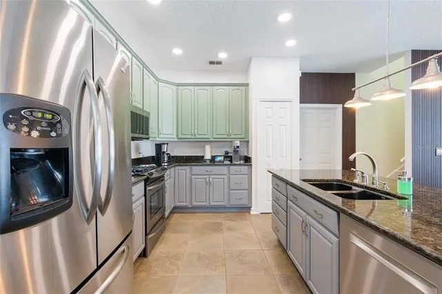 a kitchen with stainless steel appliances granite countertop a refrigerator and a sink
