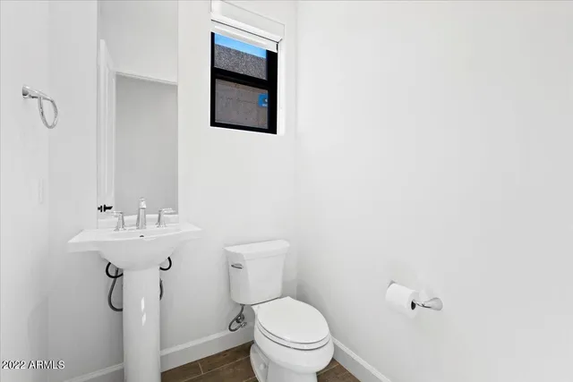 a bathroom with a toilet a sink and mirror