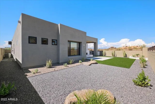 a backyard of a house with table and chairs