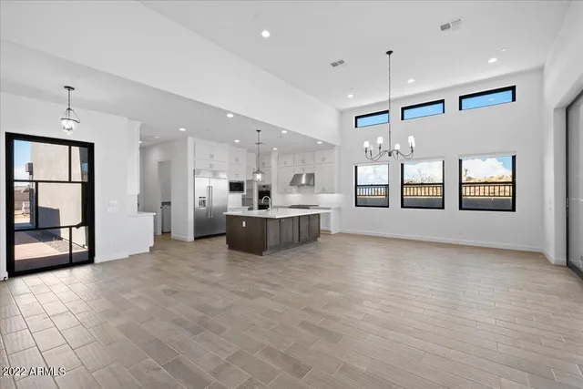 a large white kitchen with a large window and stainless steel appliances
