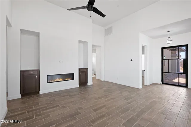 a view of an empty room with a fireplace and a window
