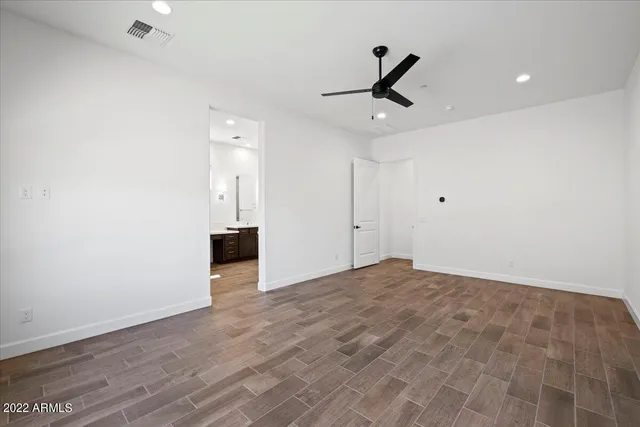 a view of empty room with wooden floor and ceiling fan