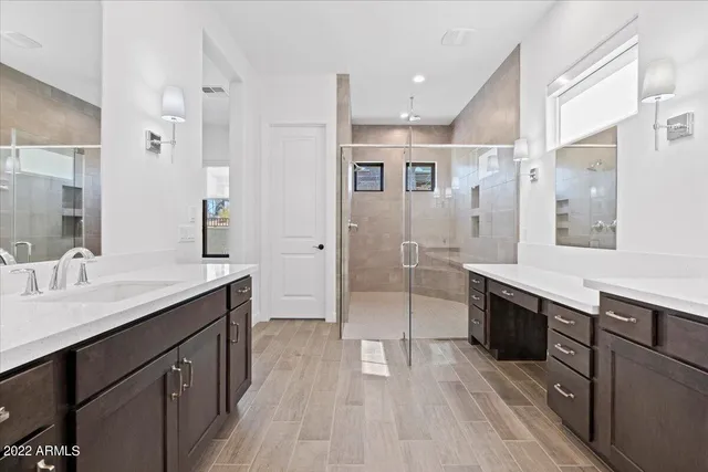 a large bathroom with a double vanity sink a mirror and a shower