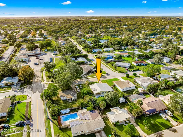an aerial view of residential houses with outdoor space and trees