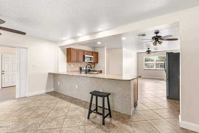 a kitchen with granite countertop a refrigerator and a sink