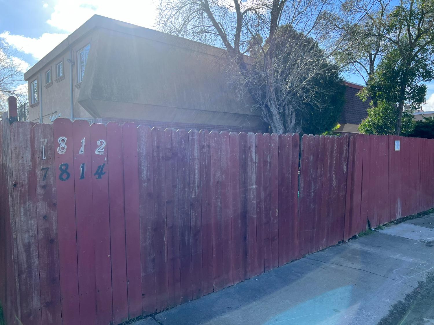 a backyard view with a wooden fence