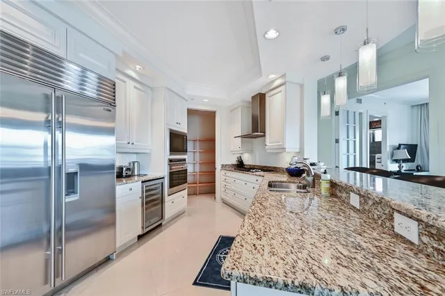 a large living room with stainless steel appliances furniture a rug kitchen view and a counter top space