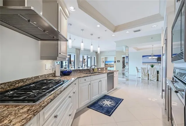 a large kitchen with stainless steel appliances granite countertop a stove and a sink