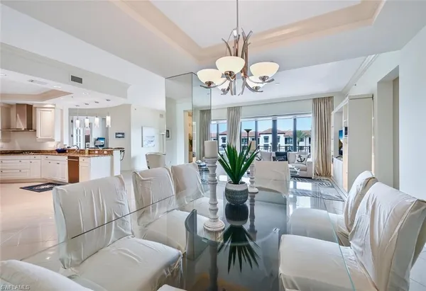 a view of a dining room with furniture a livingroom and chandelier