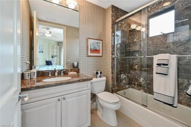 a bathroom with a granite countertop sink toilet and shower