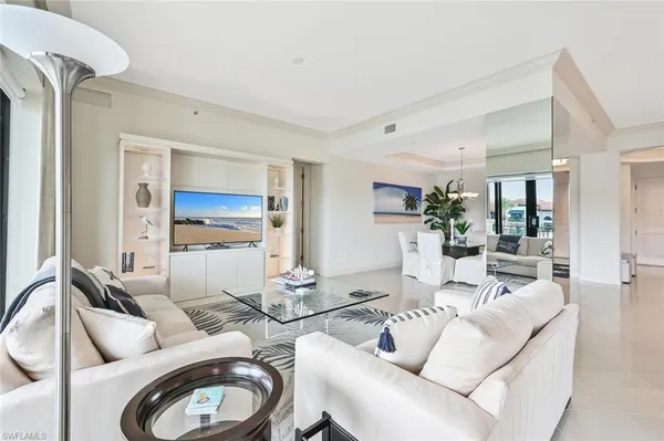 a living room with furniture a rug and a view of kitchen