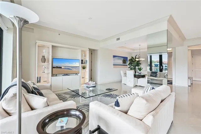 a living room with furniture a rug and a view of kitchen