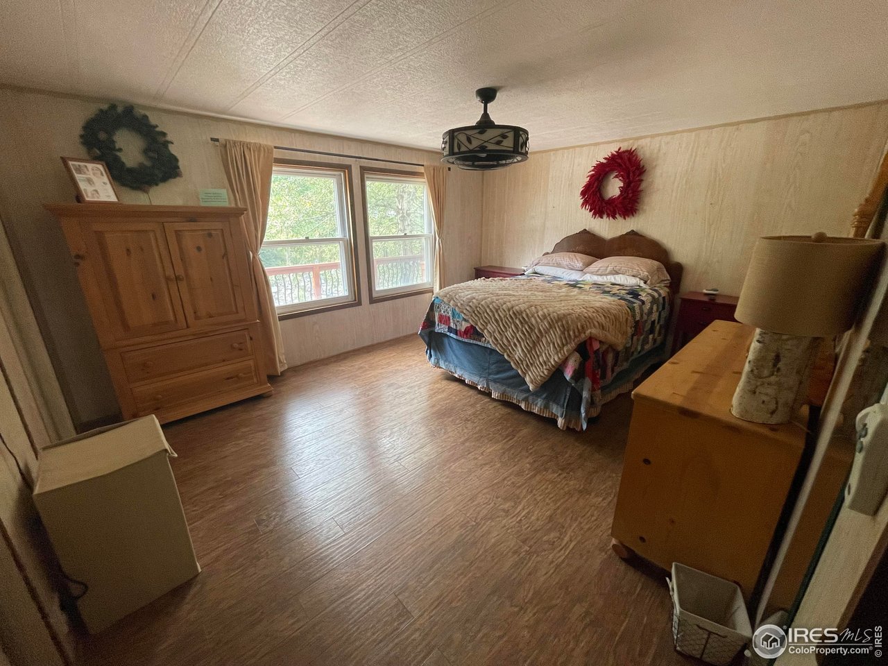 664 Riverside Drive Lyons, CO 80540 - Photo 10 of 16 a bedroom with a bed and wooden floor