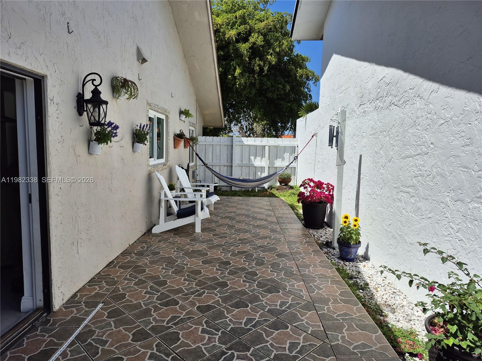14530 Southwest 110th Street Miami, FL 33186 - Photo 42 of 45 a view of a porch with furniture and flowers