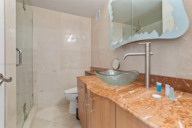 a bathroom with a granite countertop sink a toilet and a mirror