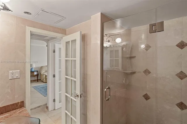a bathroom with a glass shower door and a sink