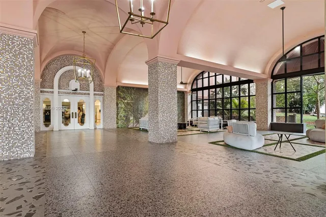 a room with lots of large windows and furniture