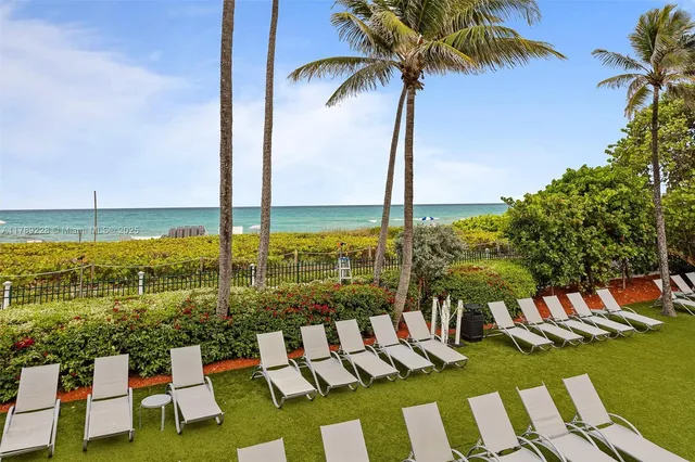 a front view of building with yard and outdoor seating