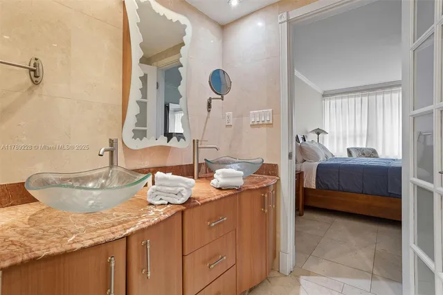 a en suite bathroom with a granite countertop sink and a mirror