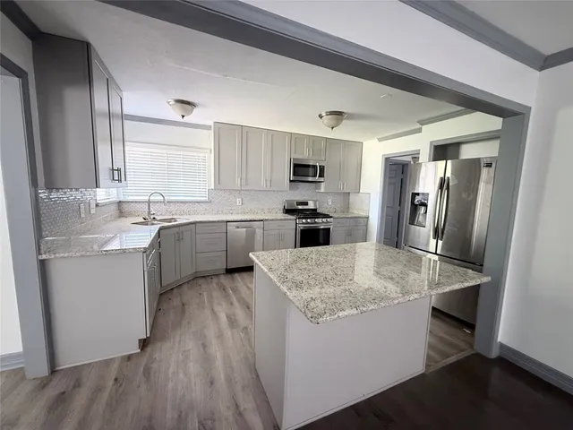 a kitchen with stainless steel appliances granite countertop a sink stove and refrigerator
