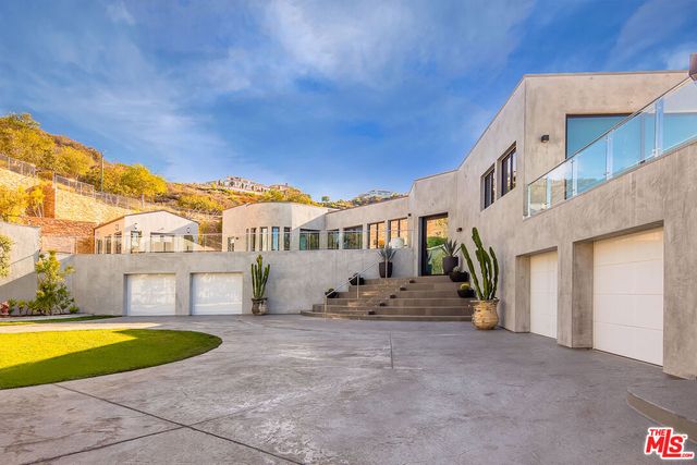 a view of a house with pool and sitting area