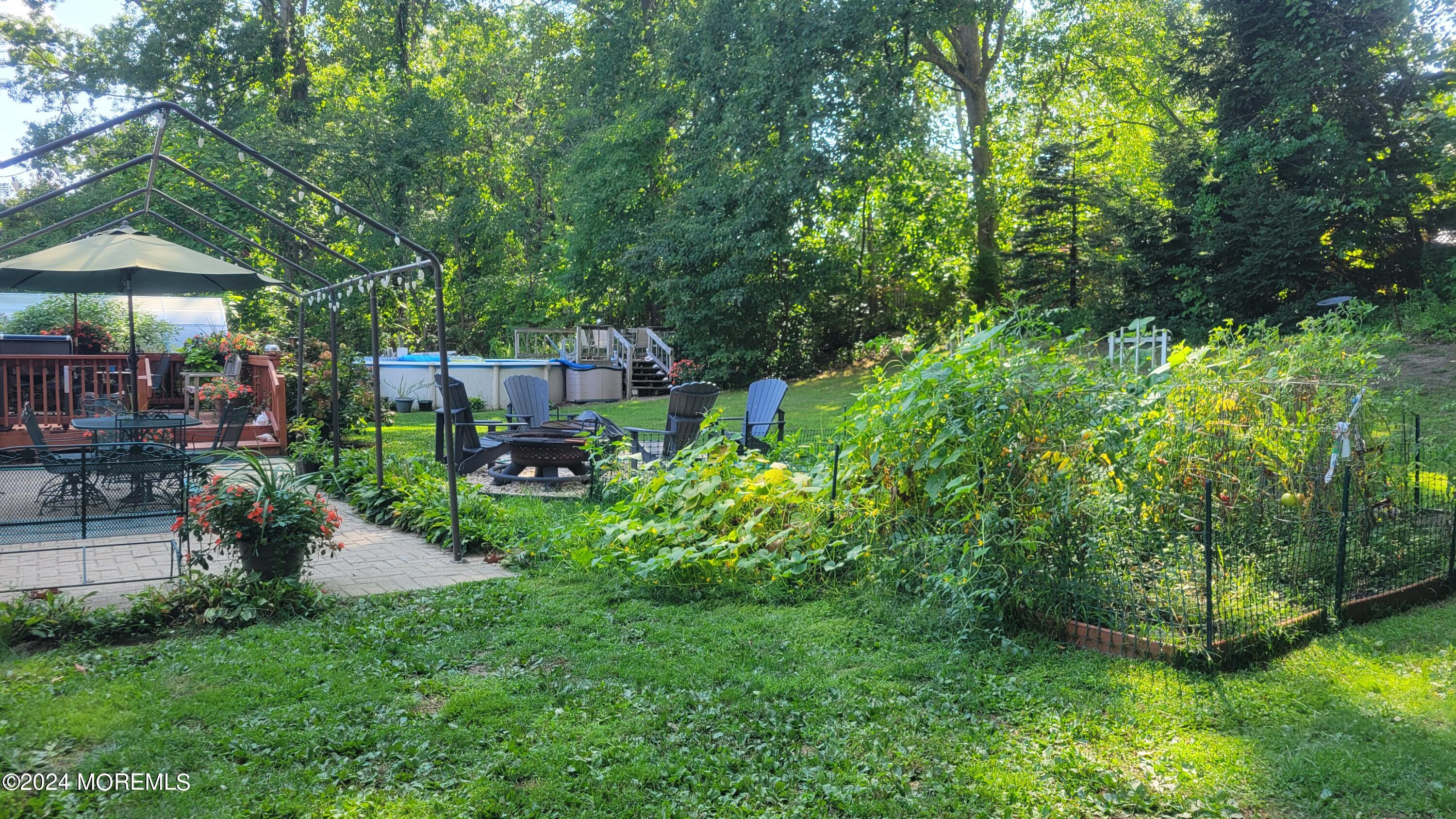 15 Bock Boulevard Howell, NJ 07731 - Photo 18 of 21 a view of a garden with a table and chairs under an umbrella