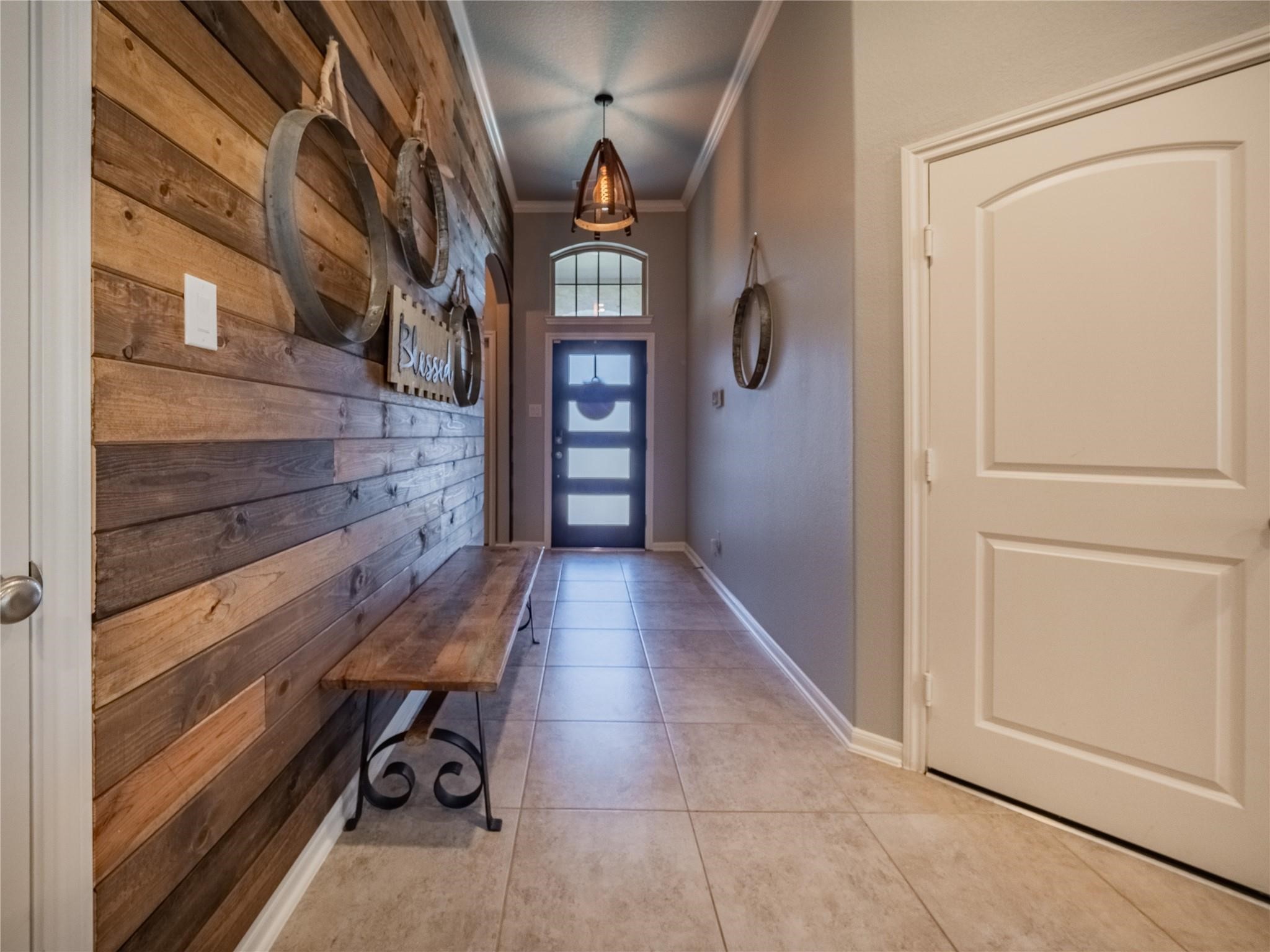 10215 Lewis Lane Iowa Colony, TX 77583 - Photo 11 of 45 Front entrance featuring a beautiful wood and glass front door, updated wood wall, chandelier, and tile flooring.