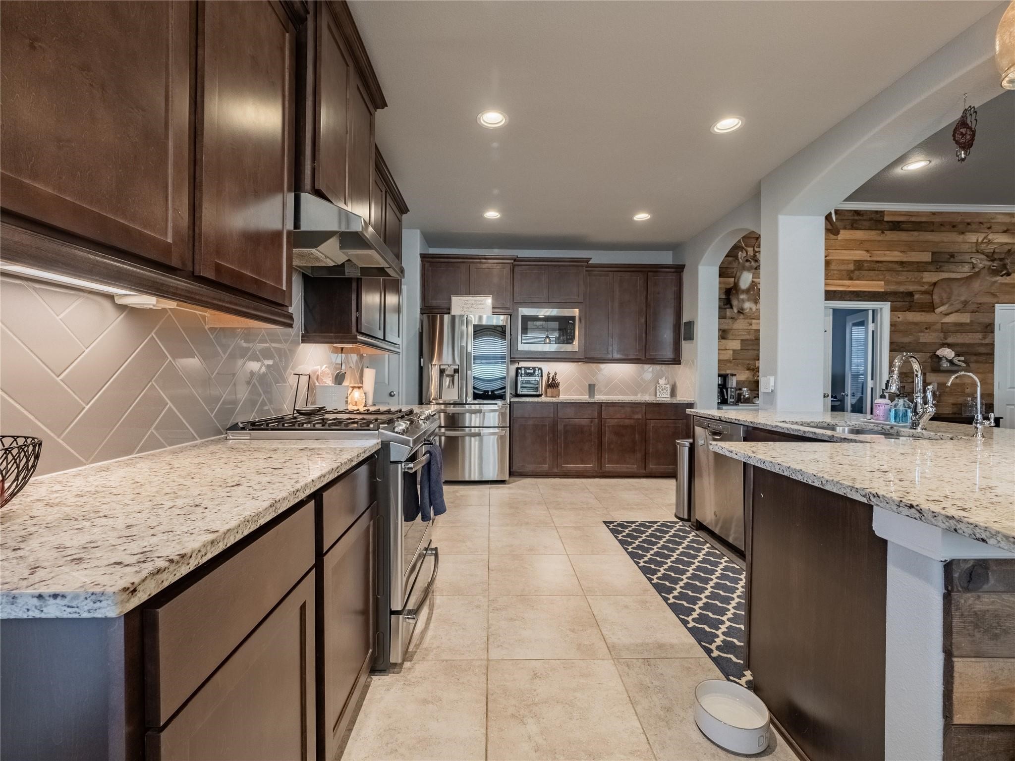 10215 Lewis Lane Iowa Colony, TX 77583 - Photo 19 of 45 a kitchen with stainless steel appliances granite countertop a sink stove and cabinets