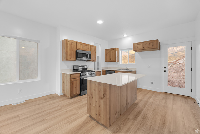 1563 South Deerbrook Road, Unit 267CHM Santaquin, UT 84655 - Photo 9 of 13 Kitchen featuring a central island with white countertop, wood-finish cabinetry, stainless steel appliances, and wood-finish flooring