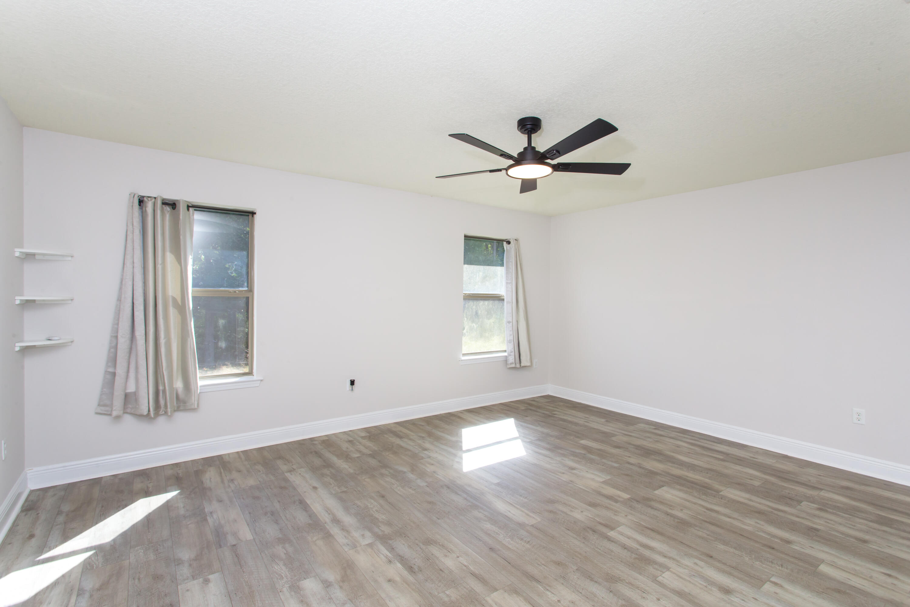 6229 Flash Lane Crestview, FL 32536 - Photo 21 of 51 an empty room with wooden floor and windows