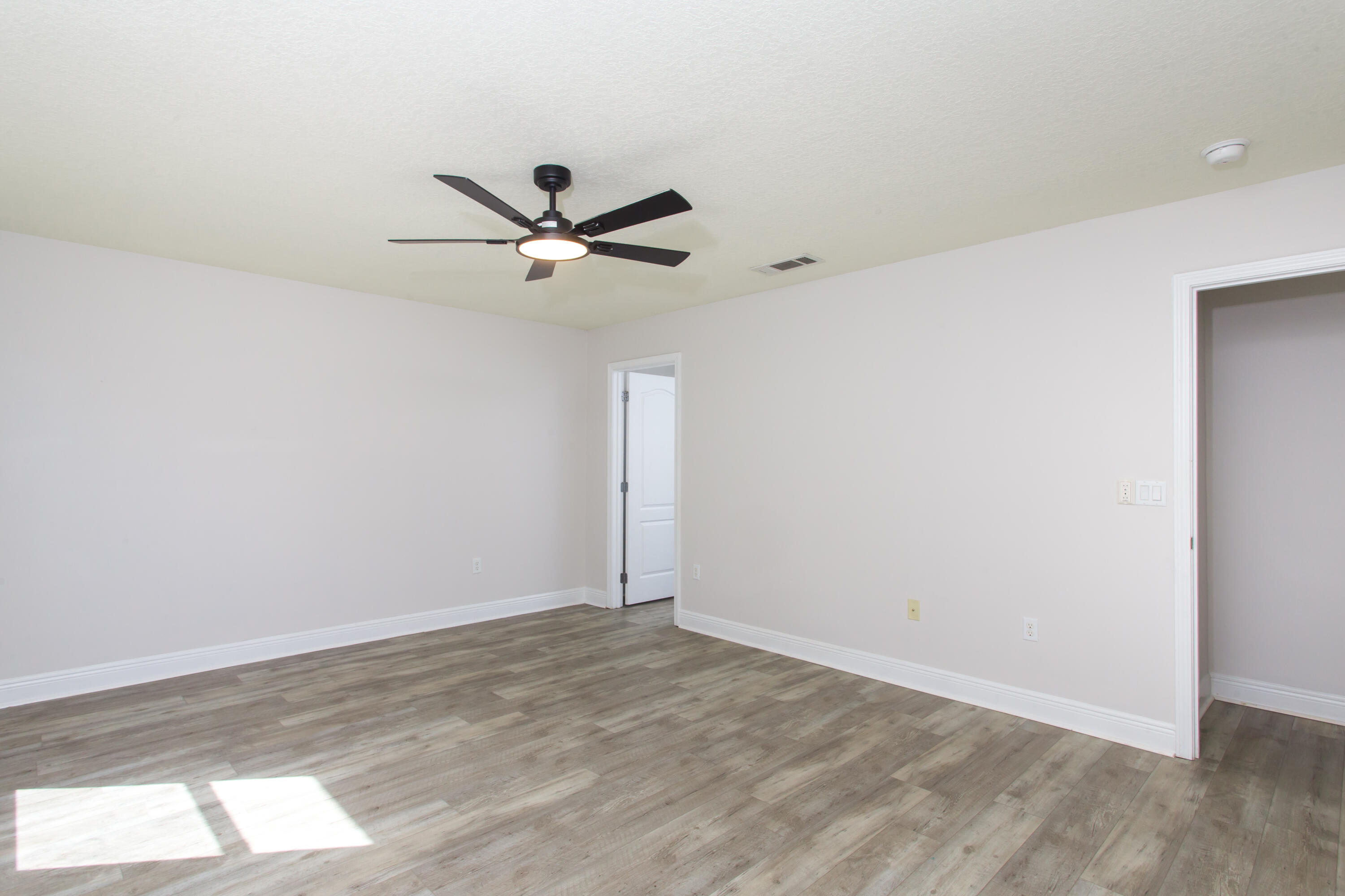 6229 Flash Lane Crestview, FL 32536 - Photo 22 of 51 a view of a big room with wooden floor and a ceiling fan