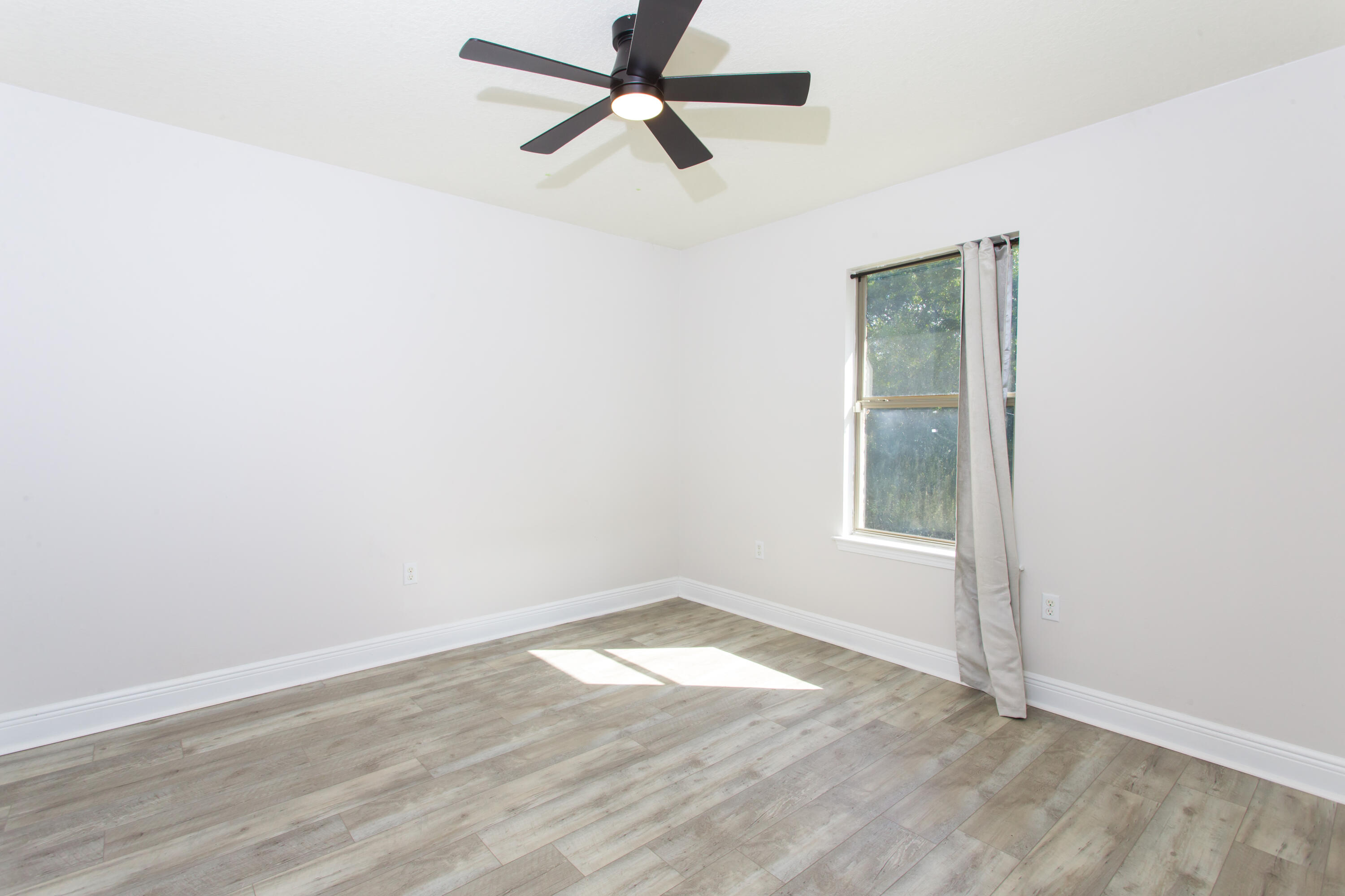 6229 Flash Lane Crestview, FL 32536 - Photo 30 of 51 an empty room with wooden floor and windows