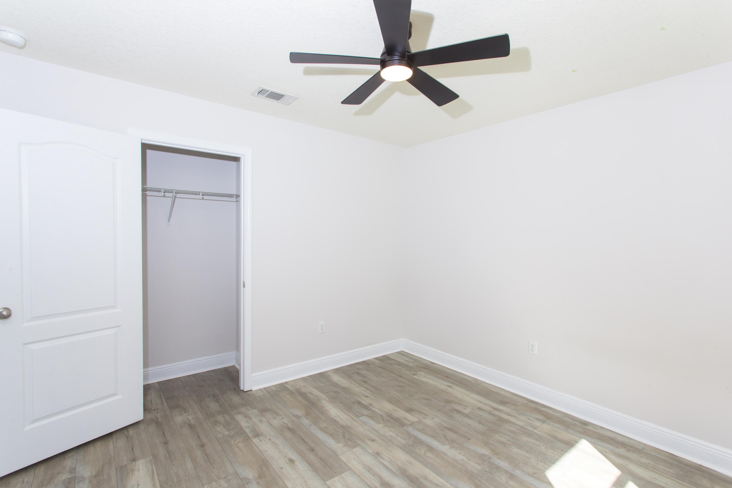 6229 Flash Lane Crestview, FL 32536 - Photo 31 of 51 a view of a room with wooden floor and a ceiling fan