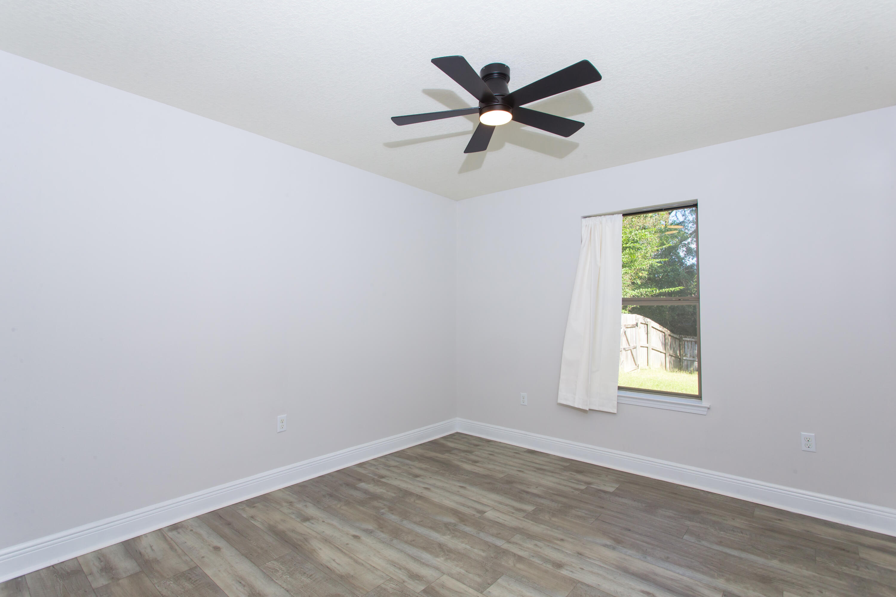 6229 Flash Lane Crestview, FL 32536 - Photo 32 of 51 an empty room with wooden floor window and ceiling fan