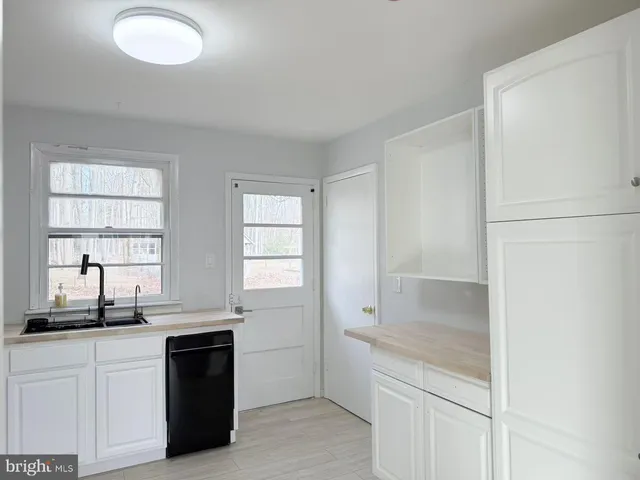 a kitchen with granite countertop white cabinets and white appliances