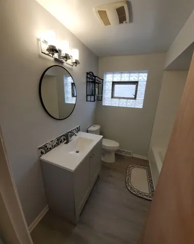a bathroom with a toilet a sink and mirror
