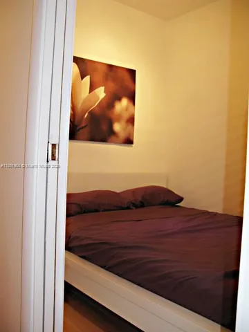 a view of bedroom with wooden floor