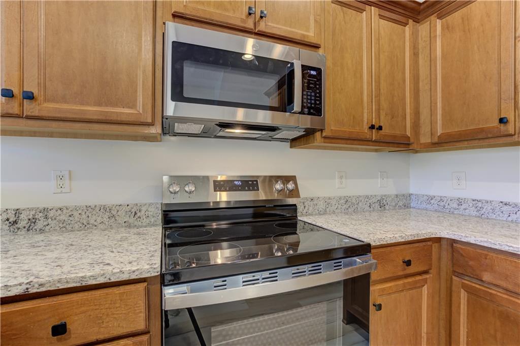 605 Summit Point Canton, GA 30114 - Photo 23 of 56 a kitchen with stainless steel appliances white cabinets and a stove top oven