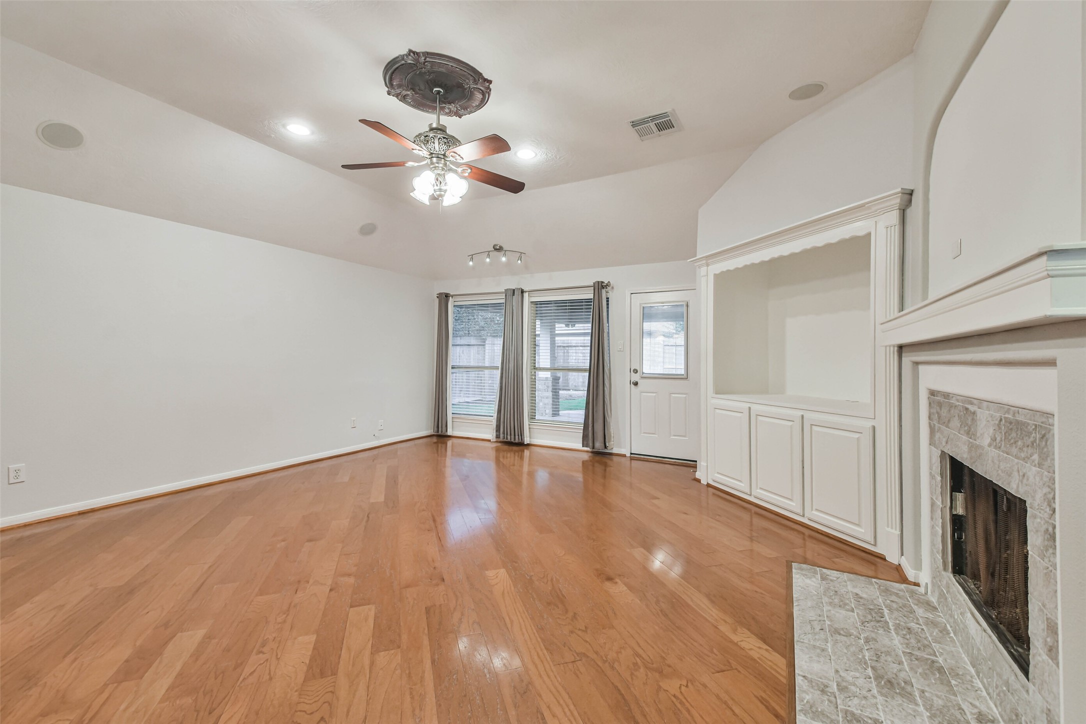 20942 Wind Field Lane Spring, TX 77379 - Photo 21 of 46 a view of an empty room with wooden floor fireplace and a window