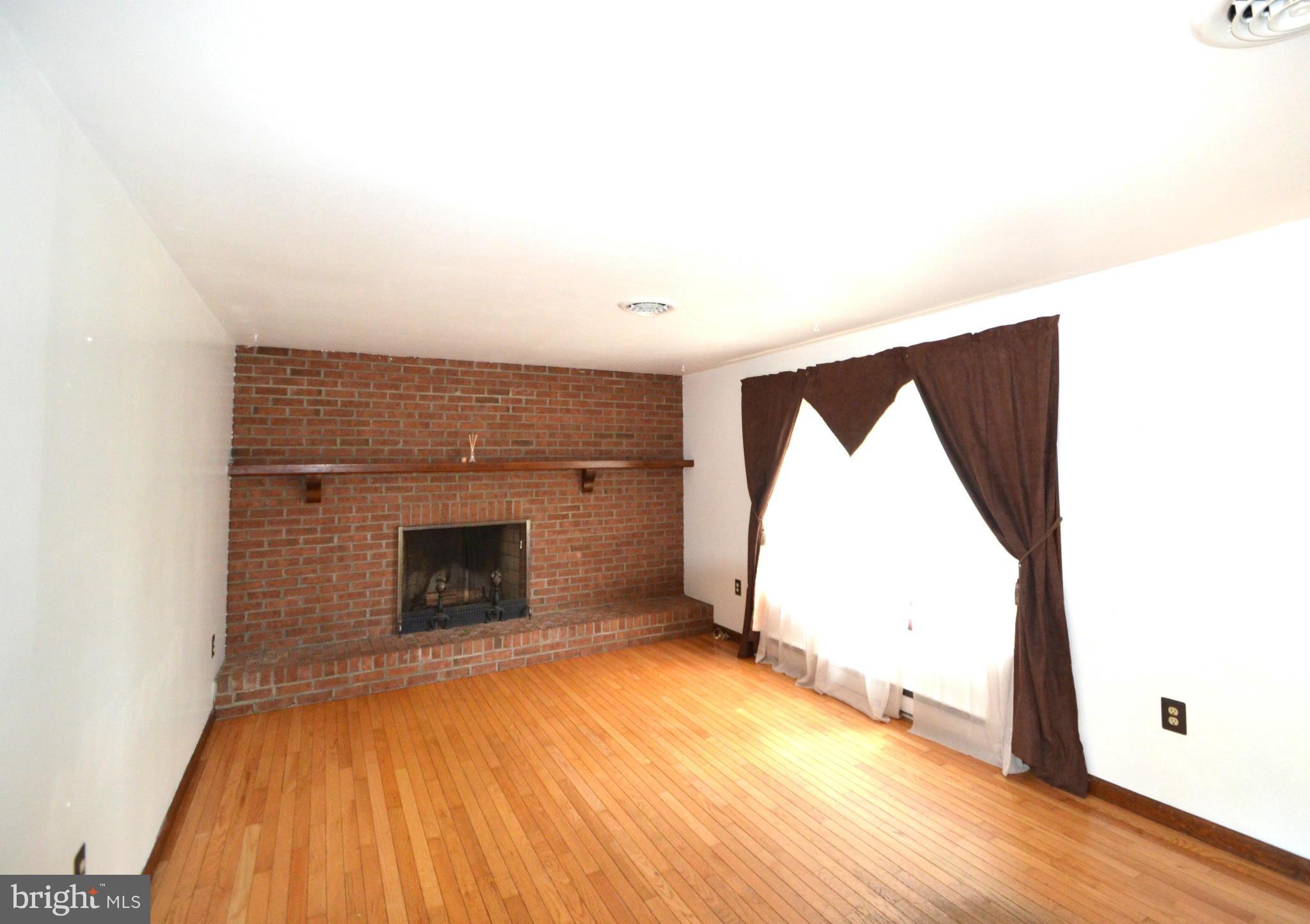 1403 Pleasant View Road Tuscarora, MD 21790 - Photo 7 of 13 a view of empty room with wooden floor and fireplace