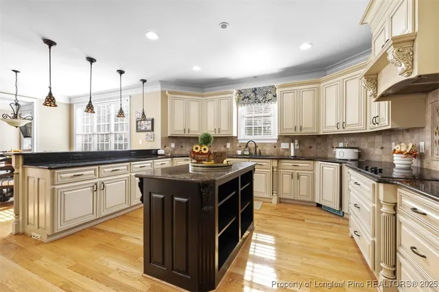 a kitchen with stainless steel appliances granite countertop a stove a sink and white cabinets