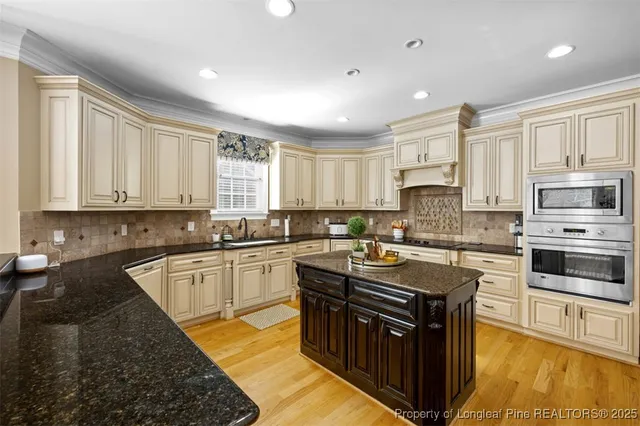 a kitchen with stainless steel appliances granite countertop a stove a sink and a microwave