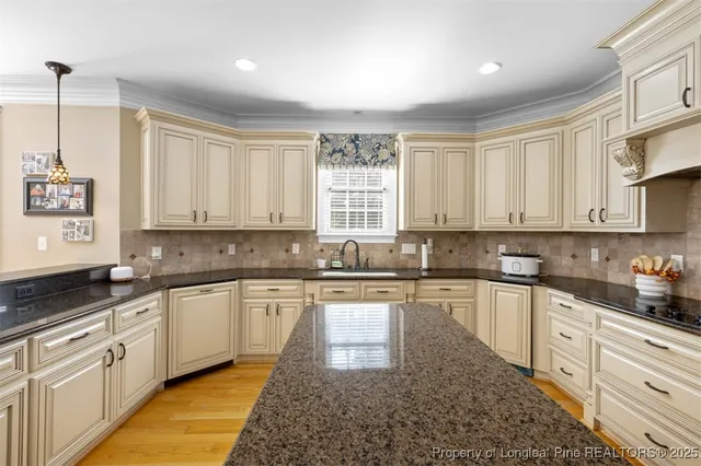 a large kitchen with stainless steel appliances granite countertop a stove a sink dishwasher and cabinets with wooden floor